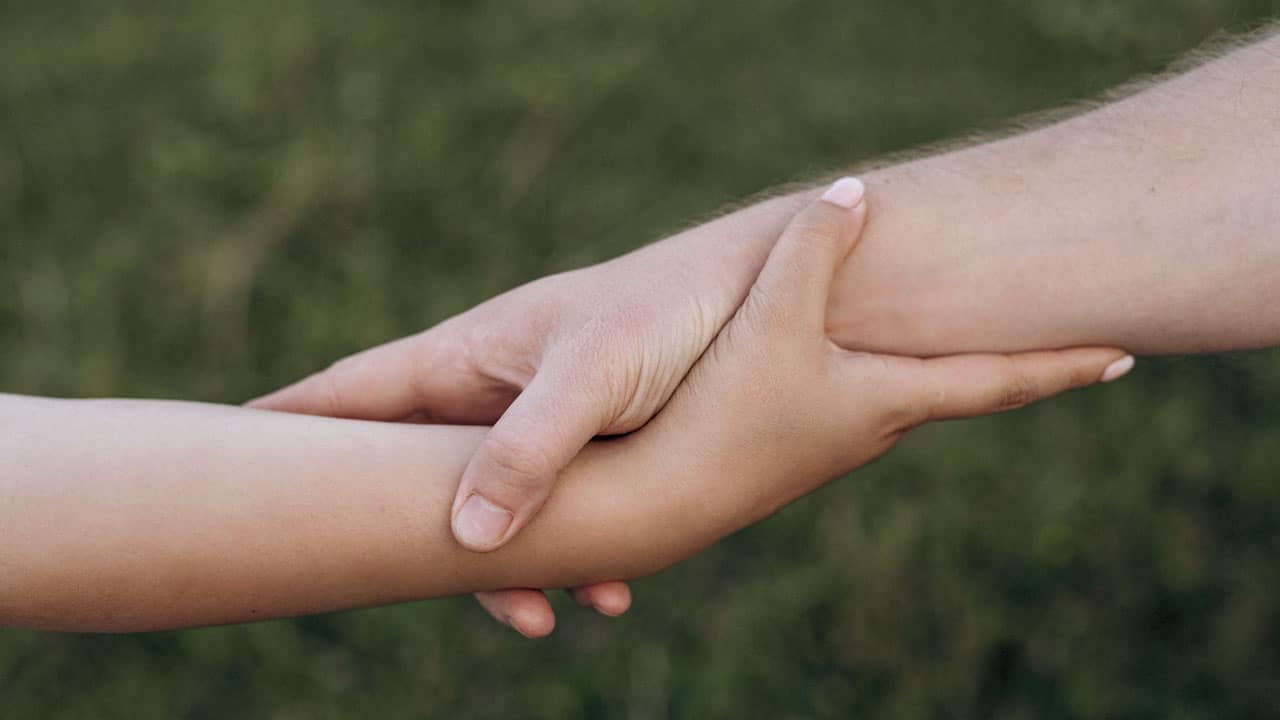 poignée de main entre un adulte et un enfant illustrant le soutien psychologique