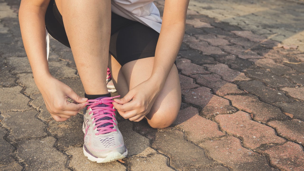 gros plan femme laçant ses chaussures illustrant le sport et handicap